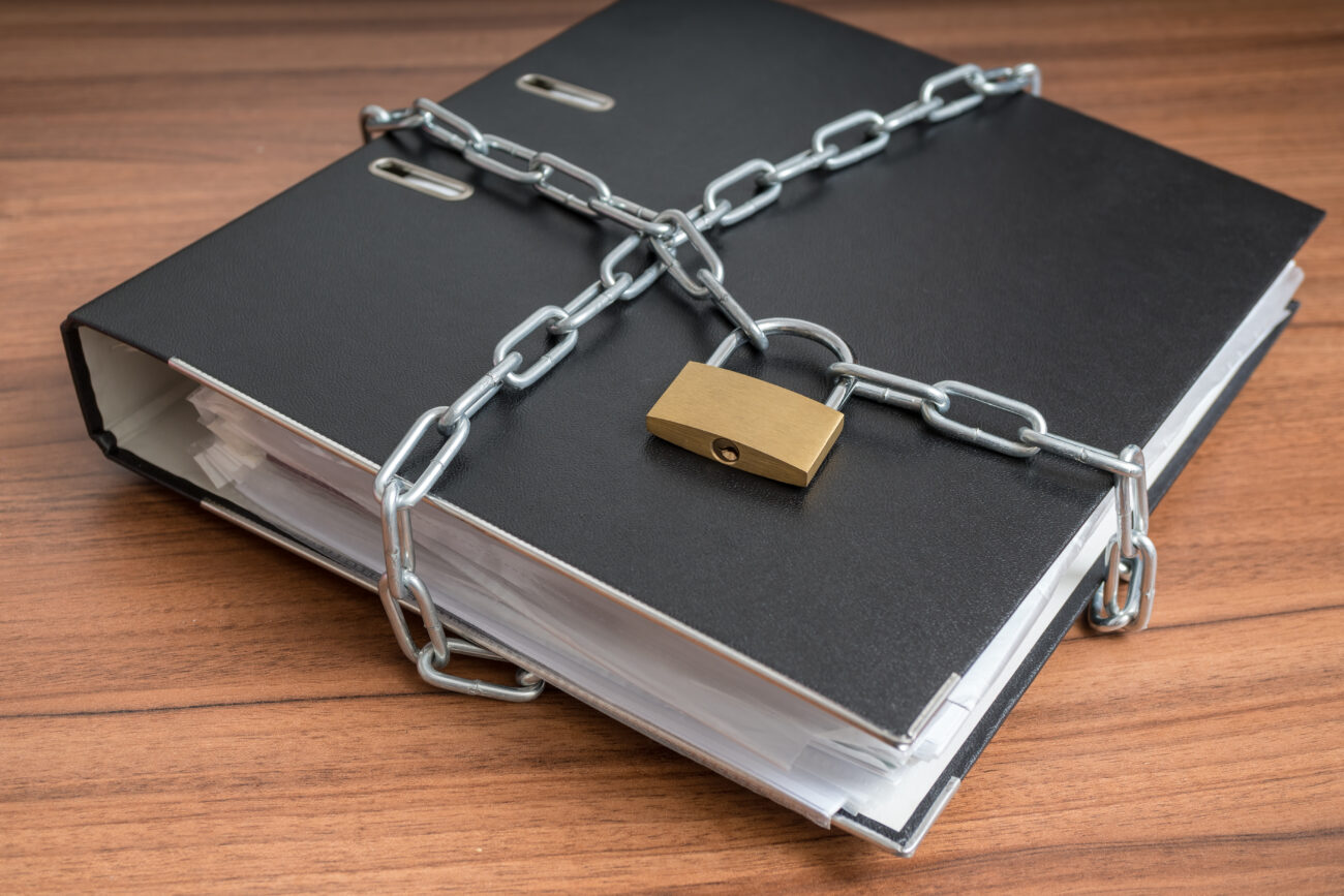 Confidential Files And Documents In Binder Locked With Padlock A