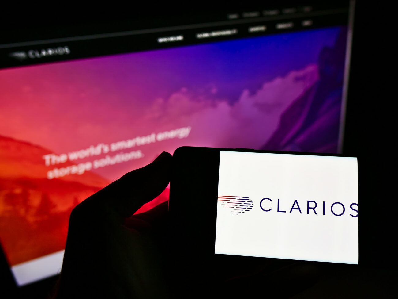 STUTTGART, GERMANY Mar 06, 2021: Person Holding Smartphone With Logo Of US Battery Manufacturer Clarios On Screen In Front Of Website