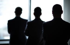 Silhouette Of Three Businessmen In The Office