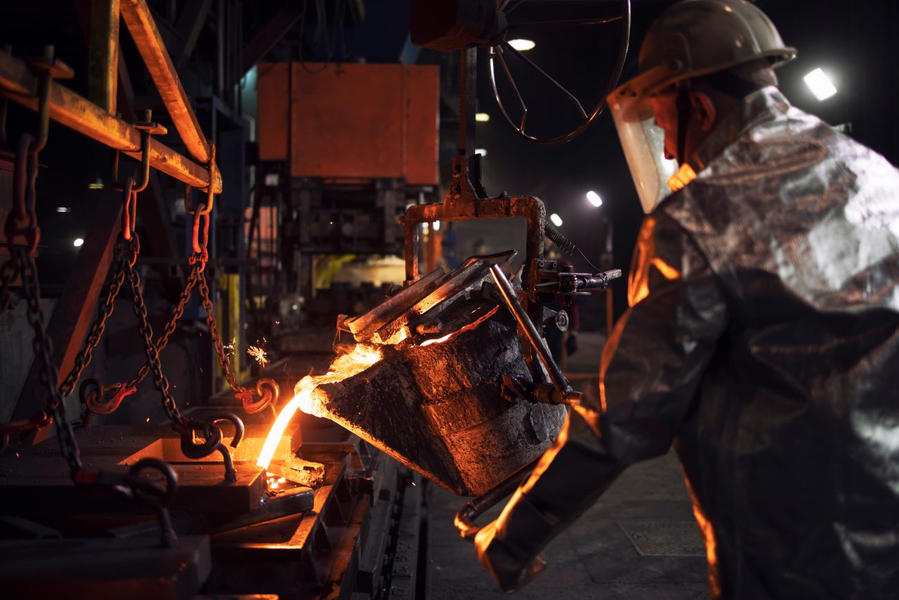 Worker In Aluminized Protection Suit Pouring Molten Steel In Fou