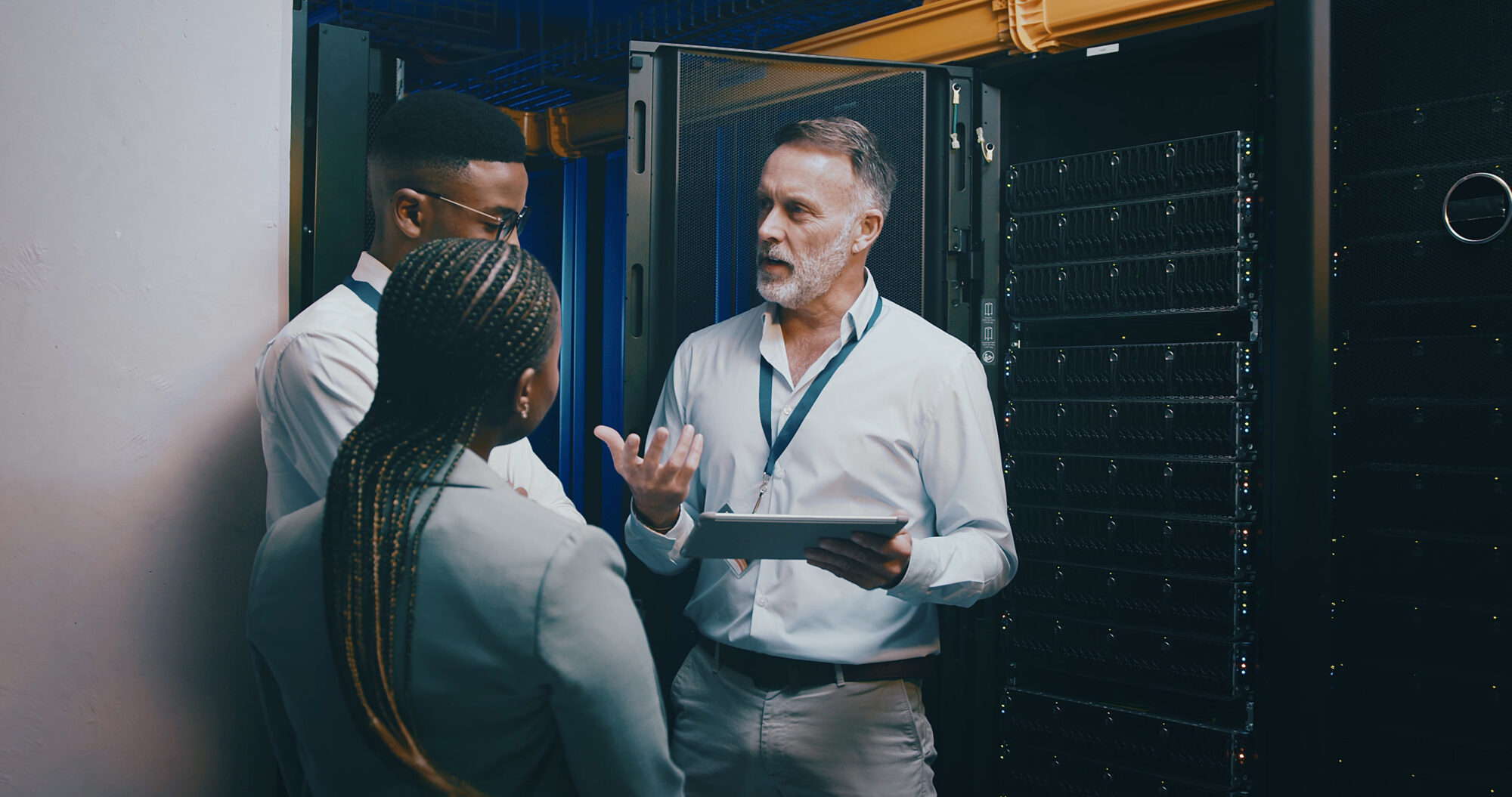 Server Room, Training And Manager With People On Tablet For Cybersecurity, Diagnostics Test And Maintenance. IT Team, Meeting And Worker With Boss For Network, Online Database And Technical Support