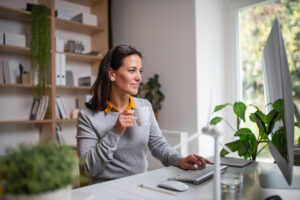 Attractive Businesswoman Sitting At The Desk Indoors In Office, Working.