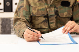 Close Up Of Executive Military Man Hands Signing Contract On A Desk At Work
