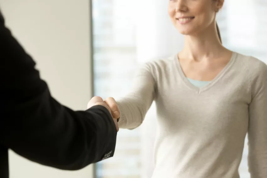 Smiling Businesswoman Shaking Businessman Hand In Office