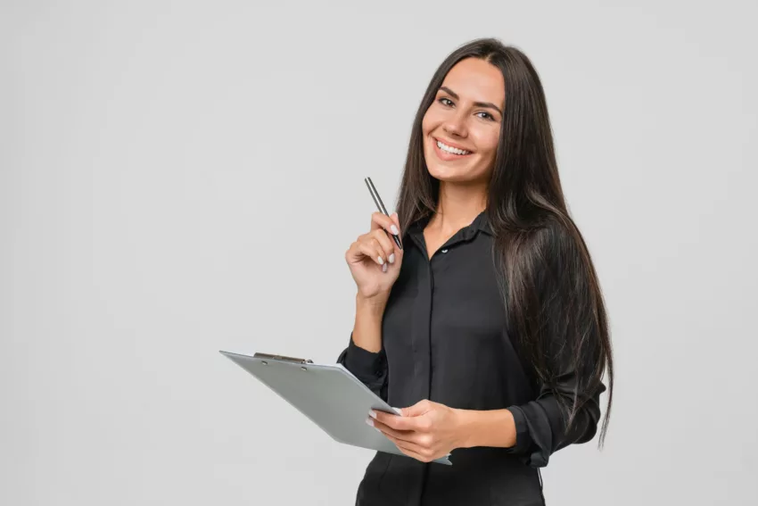 Smiling Confident Caucasian Young Businesswoman Auditor Writing On Clipboard