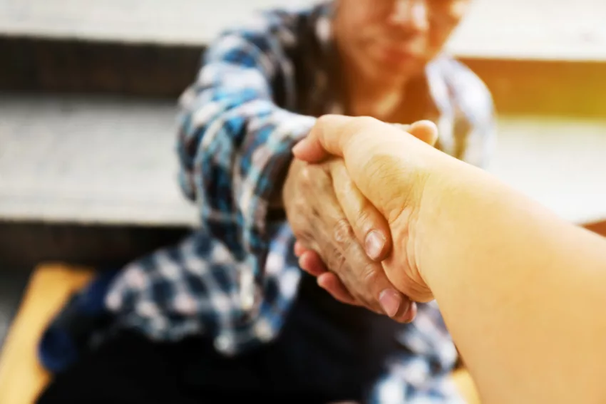 Close Up Handshake For Help Homeless Man On Walking Street In Th