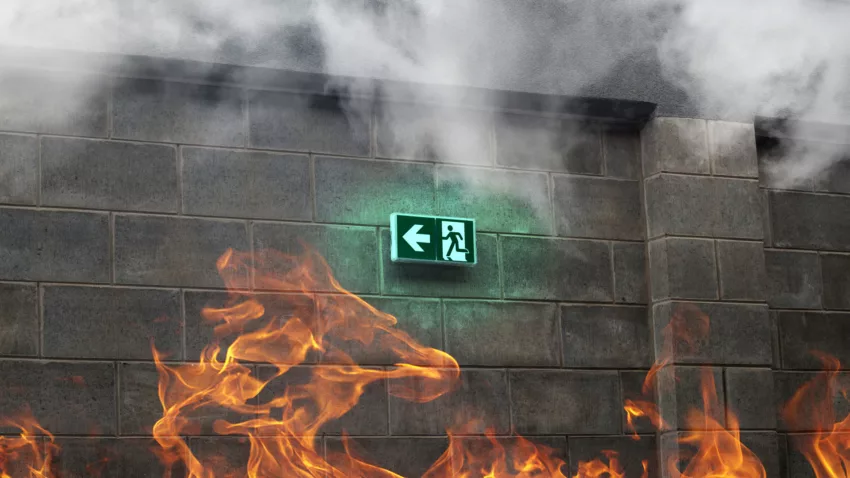 Emergency Fire Exit On The Stone Wall With Fire And Smoke